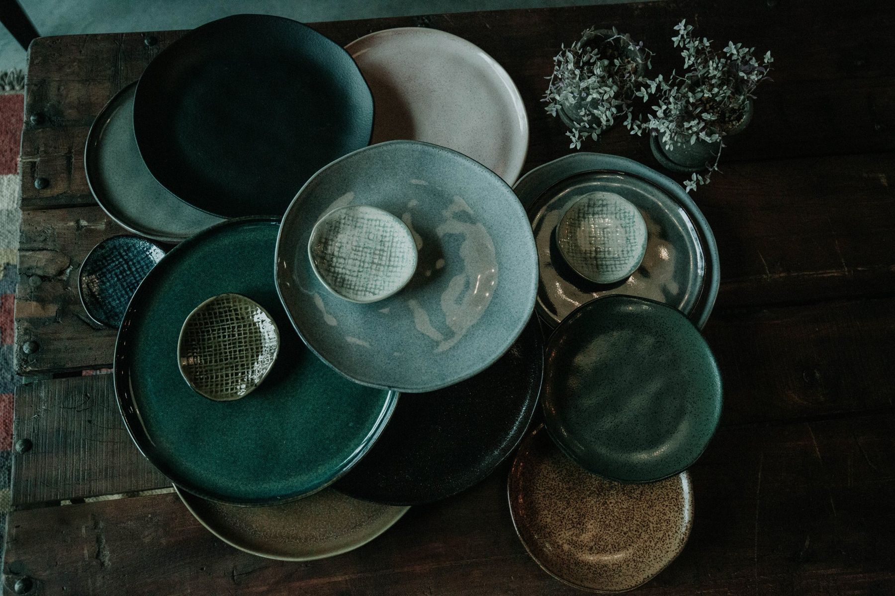 Stacked ceramic plates in greens, golds, and creams