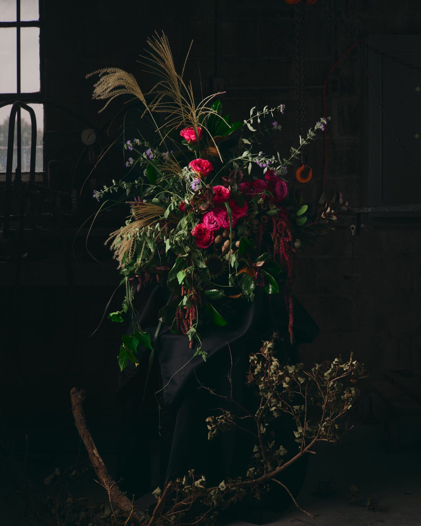 Tall arrangement of roses, grasses, and dried branches