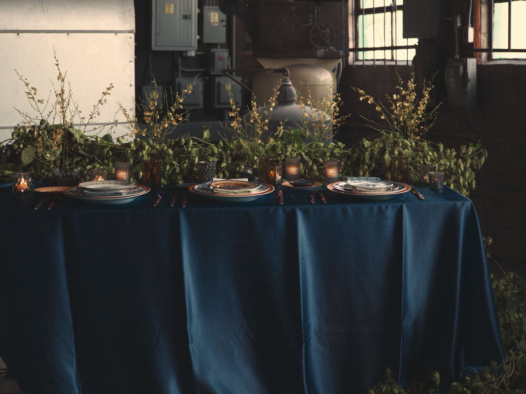 Navy-draped table with greenery and place settings