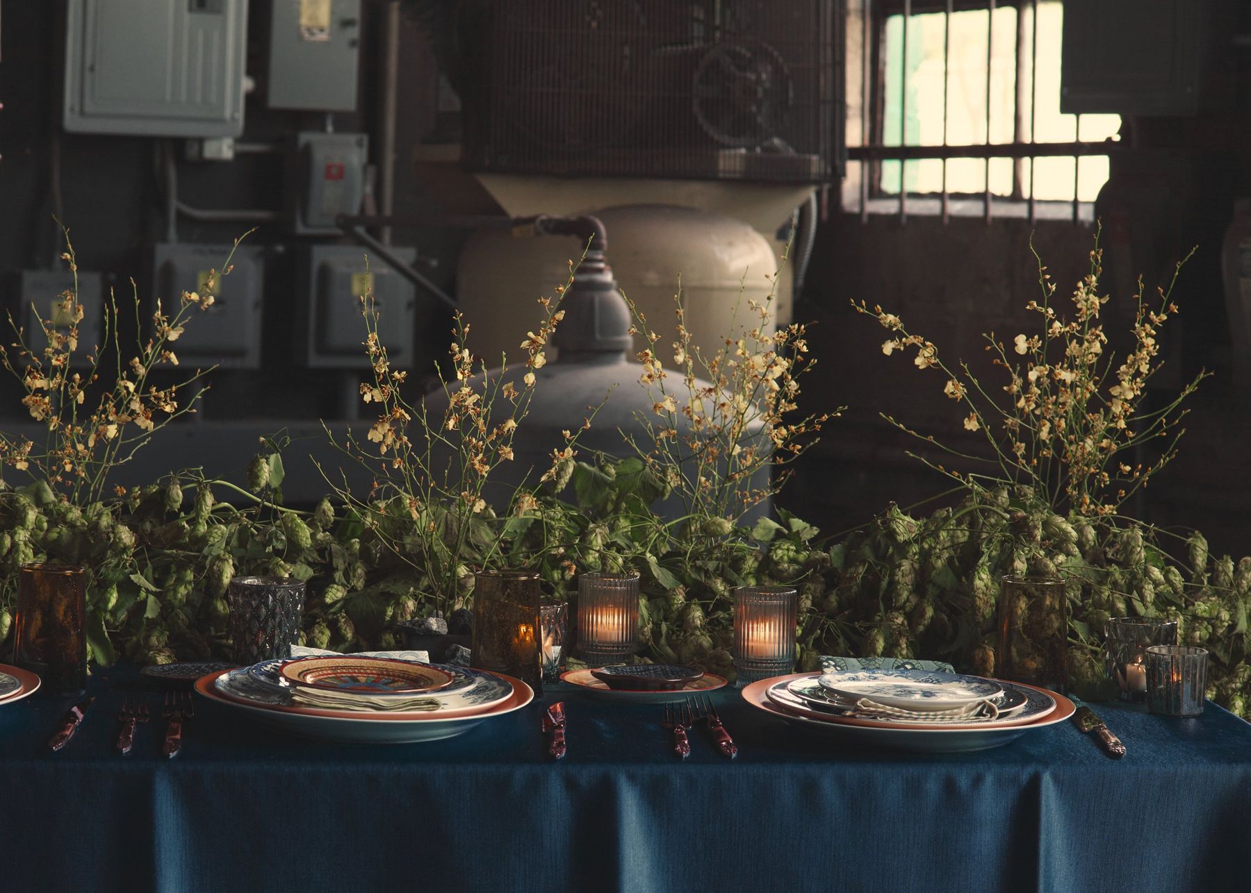 Long table dressed in navy linen with greenery and place settings