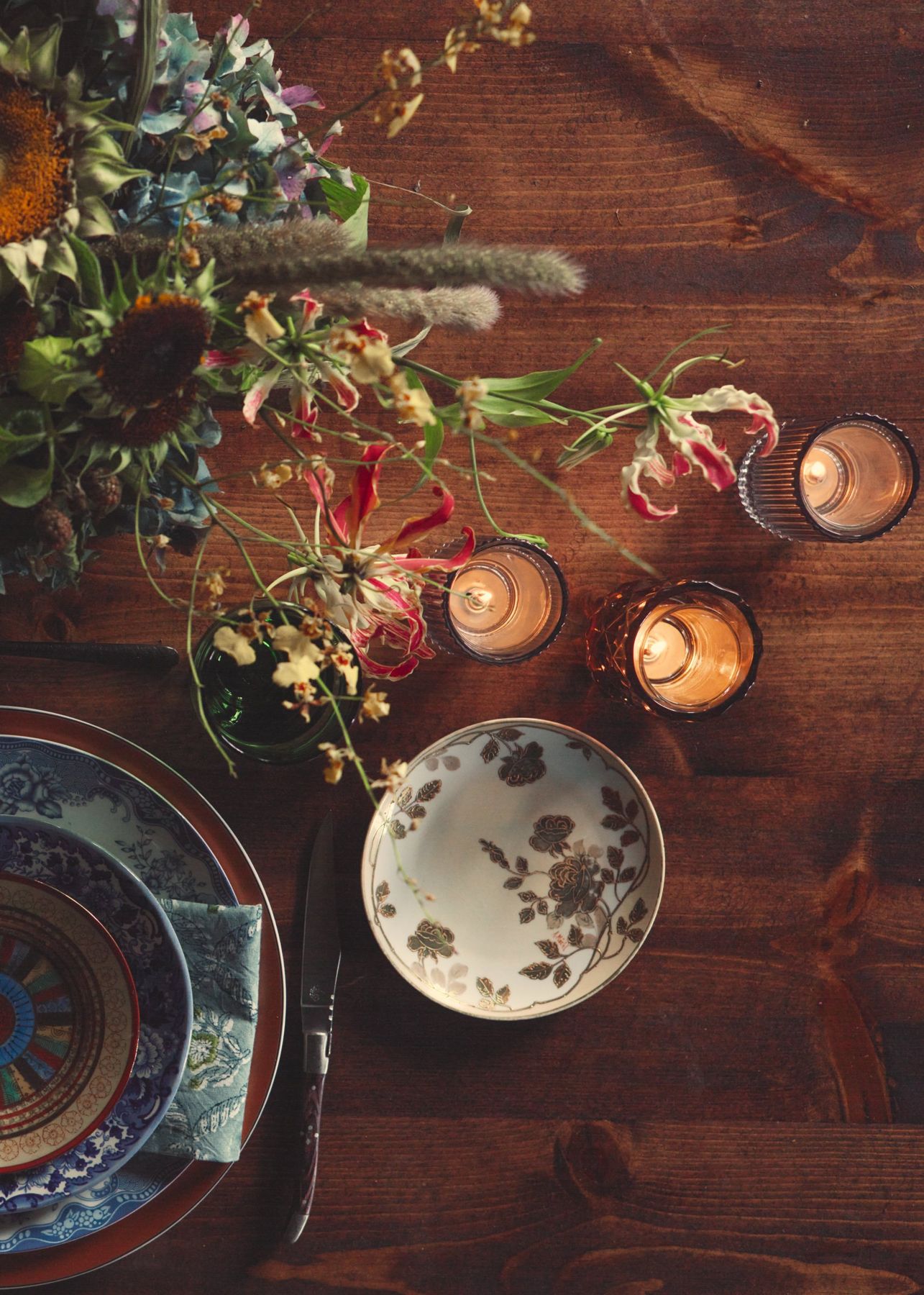 Overhead view of mixed china, candles, and flowers